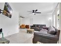 Open-concept living room featuring tile floors, modern ceiling fan, and a comfortable leather sofa at 5234 Ohio St, Winter Park, FL 32792