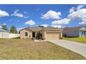 Single-story home with a two-car garage and well-kept lawn, perfect for families at 561 Lake Cummings Way, Lake Alfred, FL 33850