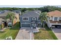 This is an aerial shot of a two-story home with a brick driveway, lush landscaping, and a gray color scheme at 5768 Los Palma Vista Dr, Orlando, FL 32837
