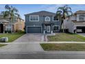 Charming two-story home featuring a brick driveway and lush landscaping at 5768 Los Palma Vista Dr, Orlando, FL 32837