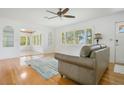 Cozy living room with hardwood floors, a ceiling fan, and ample natural light at 606 N Mcdonald St, Mount Dora, FL 32757