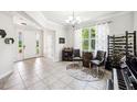Open-concept living room with tile floors, piano, and an elegant chandelier at 6080 Fender Ct, Orlando, FL 32837