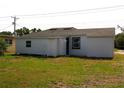 Backyard view of a white house showing a small window and door at 709 28Th Nw St, Winter Haven, FL 33881