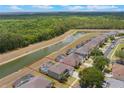 Beautiful aerial view of the home with a screened-in pool overlooking a canal and lush greenery at 8571 La Isla Dr, Kissimmee, FL 34747