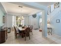 Bright dining room with tile flooring, chandelier, staircase, and an abundance of natural light at 8571 La Isla Dr, Kissimmee, FL 34747