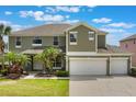 Charming two-story home with a three-car garage and well-manicured lawn and tropical landscaping at 8571 La Isla Dr, Kissimmee, FL 34747