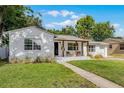 Inviting single-story home with a covered porch, patterned patio, and well-manicured lawn at 1012 N Shine Ave, Orlando, FL 32803