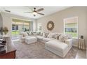 Bright living room with a large sectional sofa, ceiling fan, and sliding glass doors leading to an outdoor patio at 1082 Blackwolf Run Rd, Davenport, FL 33896