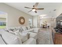 Open-concept living area with sectional sofa, ceiling fan, and a view of the dining area and natural light at 1082 Blackwolf Run Rd, Davenport, FL 33896