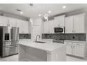 Modern kitchen boasts stainless steel appliances, white cabinets, and a spacious center island at 14160 Dove Hollow Dr, Orlando, FL 32824