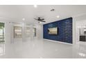 Bright living room features tile floors, and a unique textured blue accent wall with mounted television at 14160 Dove Hollow Dr, Orlando, FL 32824