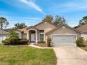 Inviting single-story home with a well-maintained lawn and an attached two-car garage at 149 Imperial Oak Ct, Davenport, FL 33896