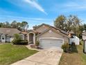 Inviting single-story home with a two-car garage and solar panels on the roof at 149 Imperial Oak Ct, Davenport, FL 33896