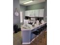 Well-lit kitchen features stainless appliances, tile backsplash and white marbled countertops with breakfast bar at 153 Pompano Beach Dr Dr, Kissimmee, FL 34746
