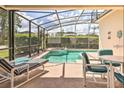 Inviting screened-in pool area with comfortable lounge chairs and seating, perfect for outdoor relaxation and entertaining at 214 Tupelo Cir, Davenport, FL 33897