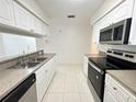 Bright kitchen with stainless steel appliances, double sinks, and white cabinets at 2330 Prime Cir # A, Kissimmee, FL 34746