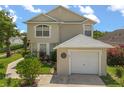 Charming two-story home with a one-car garage, manicured lawn, and vibrant landscaping at 2411 Parsons Pond Cir, Kissimmee, FL 34743