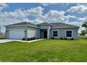 Well-maintained single-Gathering home with lush green grass, a two-car garage, and blooming flower beds at 2427 Continental Blvd, Orlando, FL 32808