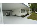 Exterior view showing covered parking area, white siding, and fresh concrete at 2618 Brookside Cir, Mount Dora, FL 32757