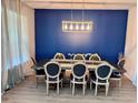 Formal dining room boasts a decorative accent wall and a modern chandelier over a table with seating for eight at 2691 Cypress Tree Trl, St Cloud, FL 34772