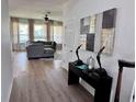 A welcoming living room with a plush gray sofa, bright windows, stylish decor and hardwood flooring at 2691 Cypress Tree Trl, St Cloud, FL 34772