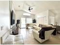 Comfortable living room with a large sectional sofa, tile floors, and sliding door access at 2711 Emerson Ln, Kissimmee, FL 34743
