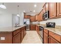 Well-equipped kitchen with granite counters, wooden cabinetry, and stainless-steel appliances at 3589 Cortland Dr, Davenport, FL 33837