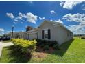 A beautiful home with a well-manicured lawn and landscaping under a sunny, blue sky at 4310 Seven Canyons Dr, Kissimmee, FL 34746