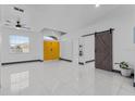 Open living area featuring tile floors, a ceiling fan, and bright yellow doors at 491 Majestic Gardens Blvd, Winter Haven, FL 33880