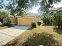 View of the front yard and two-car garage of a single-story home at 5030 Silver Thistle Ln, St Cloud, FL 34772
