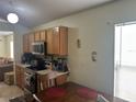 Cozy kitchen featuring wood cabinetry and laminate countertops at 5030 Silver Thistle Ln, St Cloud, FL 34772