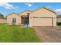Charming single-story home featuring a well-maintained lawn and brick driveway at 5253 Pebble Beach Blvd, Winter Haven, FL 33884