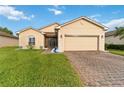 Charming single-story home featuring a well-maintained lawn and brick driveway at 5253 Pebble Beach Blvd, Winter Haven, FL 33884