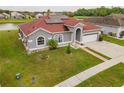 Areal shot of single Gathering home with lake view, green grass and a brick red roof at 5418 Crepe Myrtle Cir, Kissimmee, FL 34758