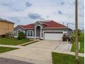 Single Gathering home features a red roof, attached garage, and lush green lawn at 5418 Crepe Myrtle Cir, Kissimmee, FL 34758