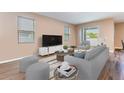 Cozy living room featuring a plush sofa, a large television, and ample natural light from large windows at 5876 Bar Ranch Rd, St Cloud, FL 34771