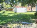 View of the property's backyard which features a storage shed surrounded by lush green grass at 622 Dromedary Ct, Kissimmee, FL 34759