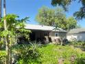 The backyard features an enclosed patio and is surrounded by vibrant greenery and mature trees at 622 Dromedary Ct, Kissimmee, FL 34759