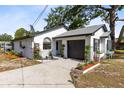 White home featuring a garage and tastefully landscaped front yard with decorative flowers and plants at 106 Edgewater Dr, St Cloud, FL 34769
