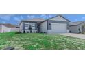 Inviting single-story home with manicured front lawn and a two-car garage with a simple design at 109 Lily Ln, Poinciana, FL 34759