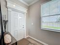 Bright foyer features elegant trim work, a large window with blinds, and stylish decor on a console table at 1373 Williams Rd, Winter Garden, FL 34787