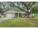 Charming single-story home featuring a mature tree, well-maintained lawn, and attached two-car garage at 17 Juniper Dr, Davenport, FL 33837