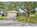 Charming single-story home featuring a mature tree, well-maintained lawn, and attached two-car garage at 17 Juniper Dr, Davenport, FL 33837