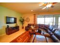 Cozy living room with a plush leather sectional, large TV, and sliding glass doors to the outdoor patio at 2147 Tripoli Ct, Kissimmee, FL 34747