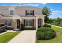 Charming two-story townhome with beige exterior, red shutters, and well-maintained landscaping at 2322 Silver Palm Dr, Kissimmee, FL 34747