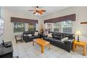 Comfortable living room with tile flooring, ceiling fan, and plenty of natural light from the many windows at 3015 Yellow Lantana Ln, Kissimmee, FL 34747