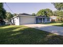 Side view of light blue single story house and two car garage with long driveway and green lawn at 3661 Se 131St Pl, Belleview, FL 34420