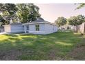 Light blue house on green lawn next to chainlink fence and green trees at 3661 Se 131St Pl, Belleview, FL 34420