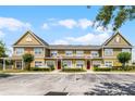 Exterior of the townhome features yellow and green siding, windows, red doors, and a white picket fence at 4551 Jonafree Ln # 103, Kissimmee, FL 34746