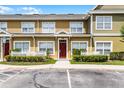 The exterior of this townhome has a red front door, white picket fence and tidy landscaping at 4551 Jonafree Ln # 103, Kissimmee, FL 34746